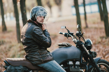 Man and old custom cafe-racer Motorcycle on forest 