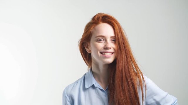 Portrait of young beautiful redhead girl smiling looking at camera. Isolated on white background.