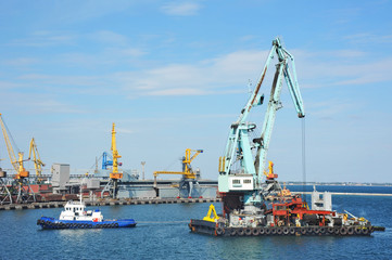 Fototapeta na wymiar Tugboat assisting floating cargo crane