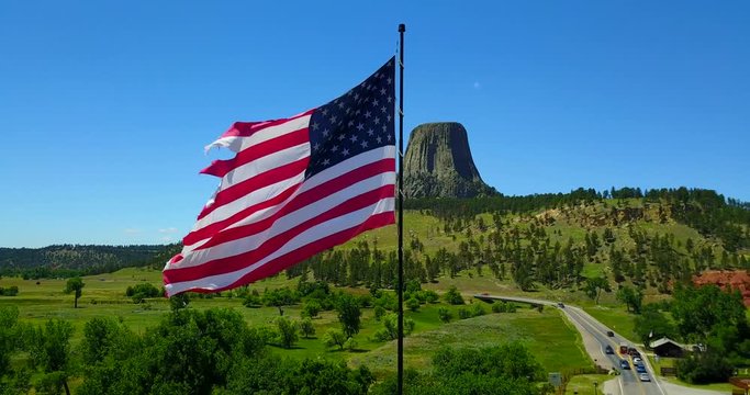American Flag Waving In Breeze Outside Devil's Tower, Wyoming - Aerial Flyover Pan View