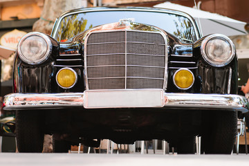 Close-up of front part of black vintage car. Exhibition