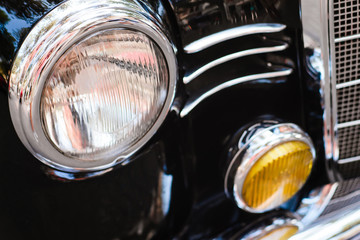 Close-up of front headlight of black vintage car.