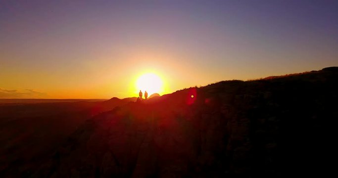 Climbers On Mountain Ridge Silhouetted By Sunset - Aerial Panning Footage