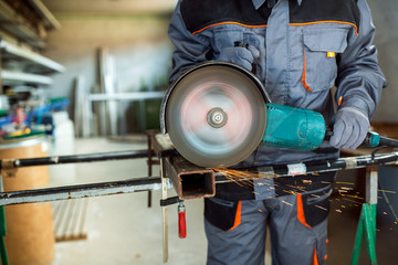 Worker cutting metal with grinder.