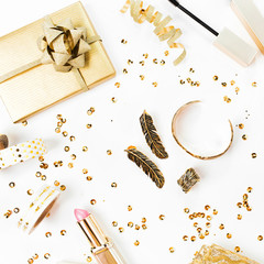 Frame with gift, sequins, makeup cosmetics kit  and other accessories on white background. Composition in gold colors. Flat lay, top view.