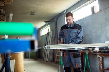 Worker with drilling mashine in workshop