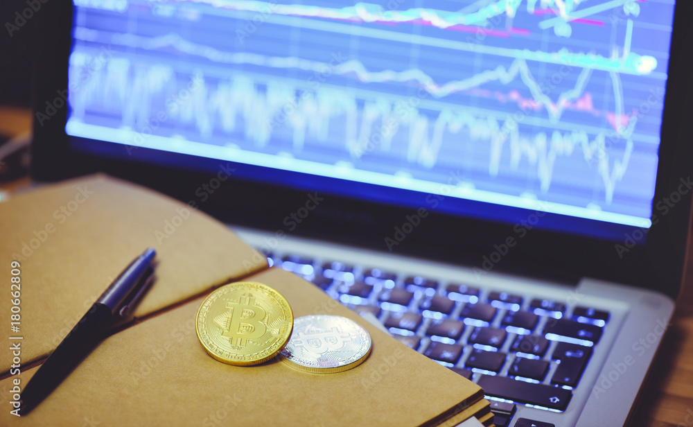 Fototapete Bitcoin is a gold coin in the notebook of a business man against a computer background and an increasing graphics. The concept of virtual crypto currency
