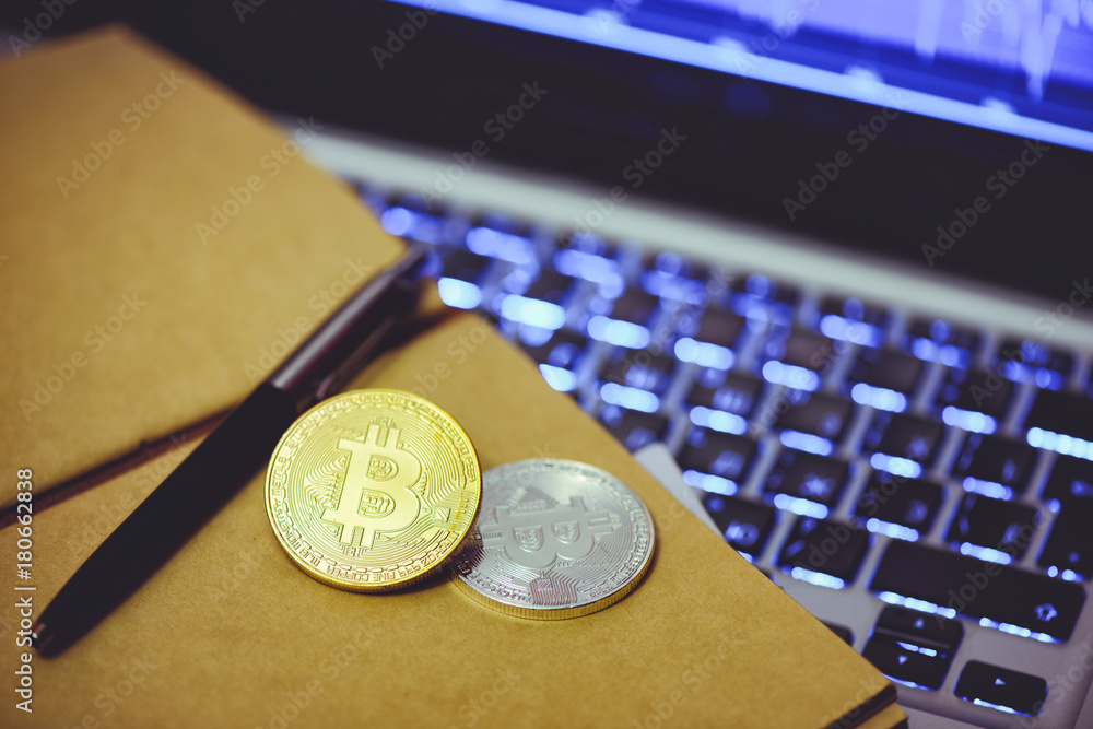 Fototapete bitcoin is a gold coin in the notebook of a business man against a computer background and an increa