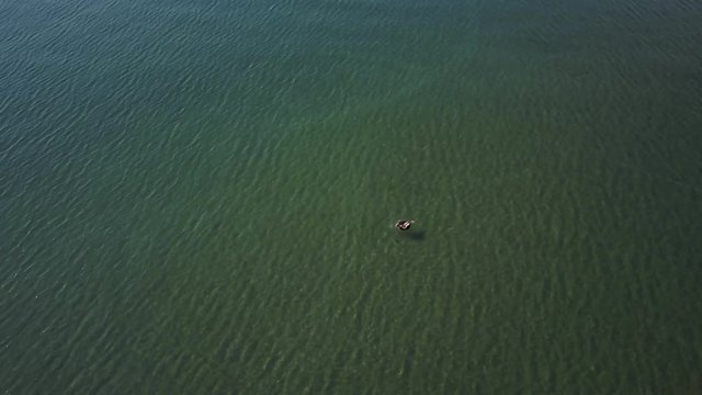 A beautiful mature caucasian woman in a rubber tube in a huge sea.