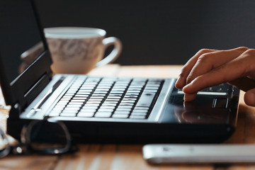 Close-up of hands of man typing on a laptop