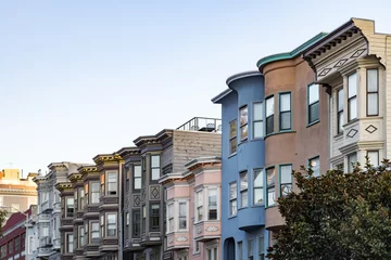 Fotobehang Sunset light shines on a row of colorful buildings on Filbert Street in San Francisco, California © deberarr
