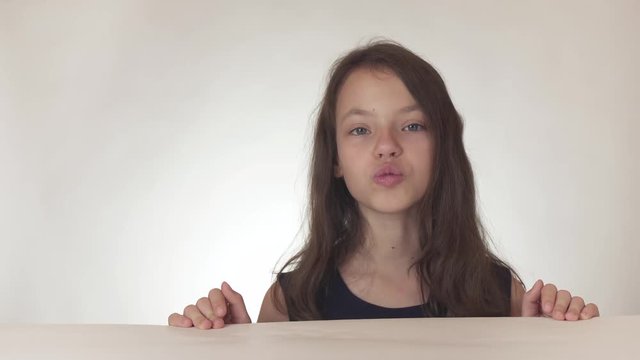 Beautiful naughty teenage girl joyfully sends kisses to the air on white background stock footage video