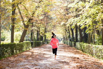Fototapeta premium attractive and happy runner woman in Autumn sportswear running a