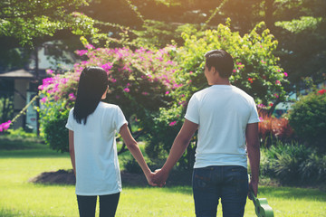 Young Couple Holding Hands Walking Away together.