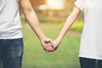 Obraz premium Young Couple Holding Hands Walking Away together.