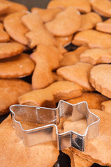 Cookie cutters in shape of star and fresh baked gingerbread or cookies for Christmas