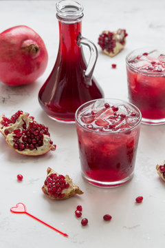 Pomegranate juice in glass with ice and pomegranate fruit