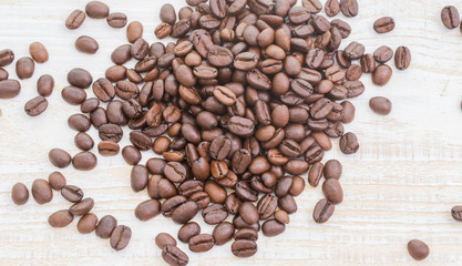 Naklejka premium Coffee beans on wood background
