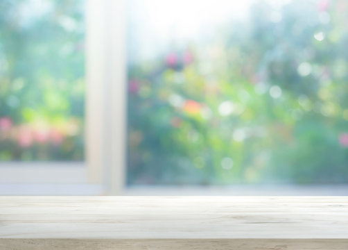 Wood Table Top On Blur Of Window With Garden Flower Background In Morning.For Montage Product Display Or Key Visual Layout