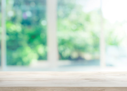 Fototapeta Wood table top on blur of window with garden flower background in morning.For montage product display or key visual layout