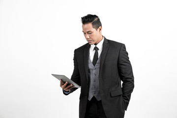 Naklejka na ściany i meble Business man standing playing tablet on white background
