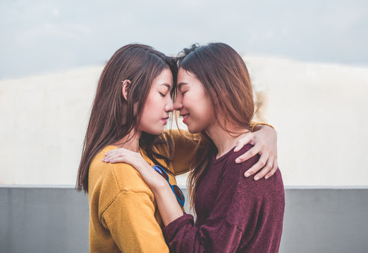 Asia Lesbian LGBT Couple Hug And Nose Kiss On Rooftop Of Building With Happiness Moment.