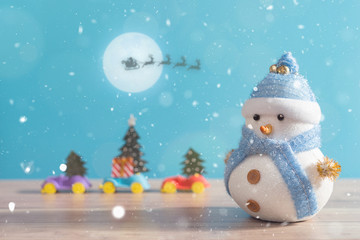 Happy snowman standing in blue winter christmas snow background. Merry christmas and happy new year greeting card with copy-space. Christmas celebration holiday background