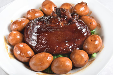 Braised pork trotters in brown sauce with eggs on the plate  