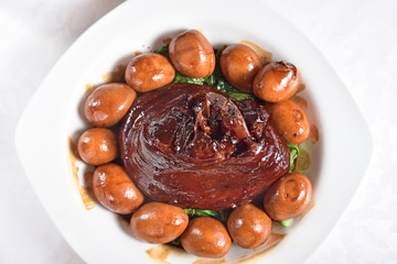 Braised pork trotters in brown sauce with eggs on the plate  