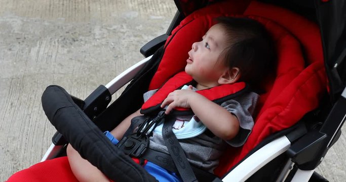 cute boy child happy in baby stroller carriage seat