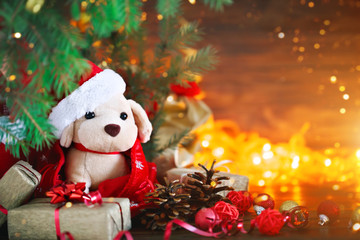 Obraz premium Christmas decoration, holiday plush dog with gifts under the Christmas tree. With New Year and Christmas.