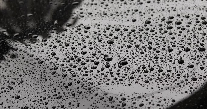 water rain drops on black car with glass coating