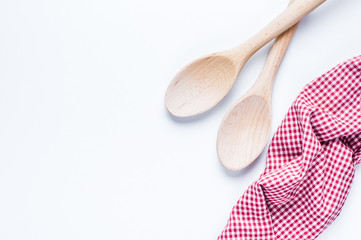 Wooden spoon and red checkered fabric on a white background