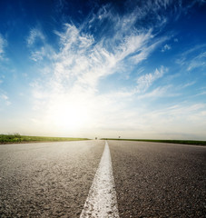 sunset in deep blue sky over asphalt road