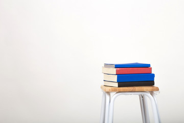 A stack of books on a chair. Isolated a white background.