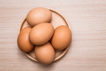 Close-up view of chicken eggs on wooden table background