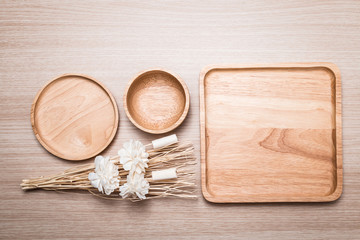 Fototapeta na wymiar Wood dish with dried flower on the wooden background.