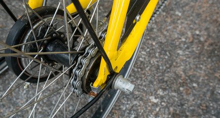 close up of bike chain ring on yellow bike.