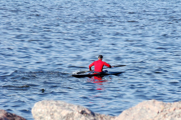 a man in a red jacket sailing kayak
