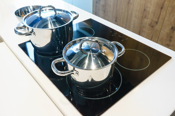 Metal Pot on induction hob in modern kitchen. modern kitchen pot cooking induction electrical stove hob concept © navintar