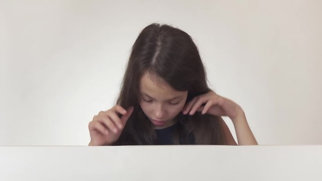 Beautiful girl teenager reflects, looks at the poster with the information, finds there what she wanted and is thrilled on white background stock footage video.