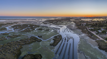 Aerial dusk seascape of oyster production, in Ria Formosa wetlands nature conservation park,...