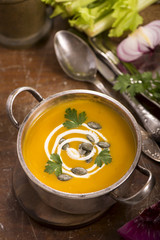pumpkin soup on rustic wooden background