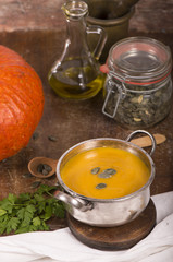 pumpkin soup on rustic wooden background