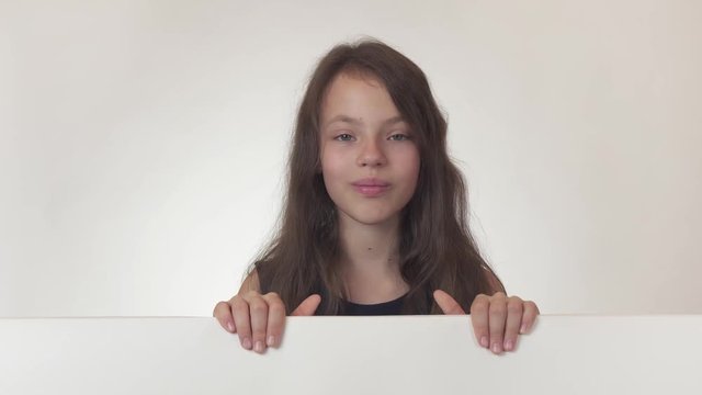 Beautiful girl teenager looks at a poster with information and licked with pleasure on white background stock footage video.