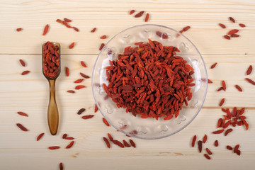 Goji berries in glass bowl on wooden table