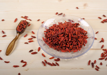 Goji berries in glass bowl on wooden table