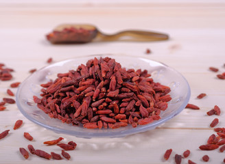Goji berries in glass bowl on wooden table