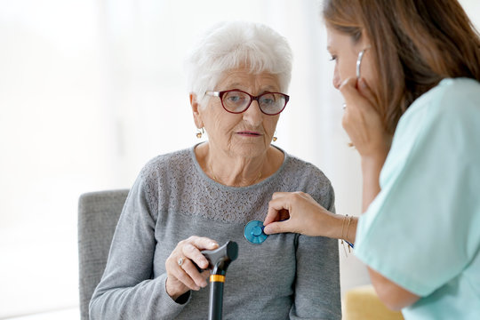 Nurse examining old woman in nursing home