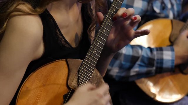 Woman playing music with balalaika. Lifestyle concept. Russian instrument. Folk music russian ensemble - woman playing the balalaika
